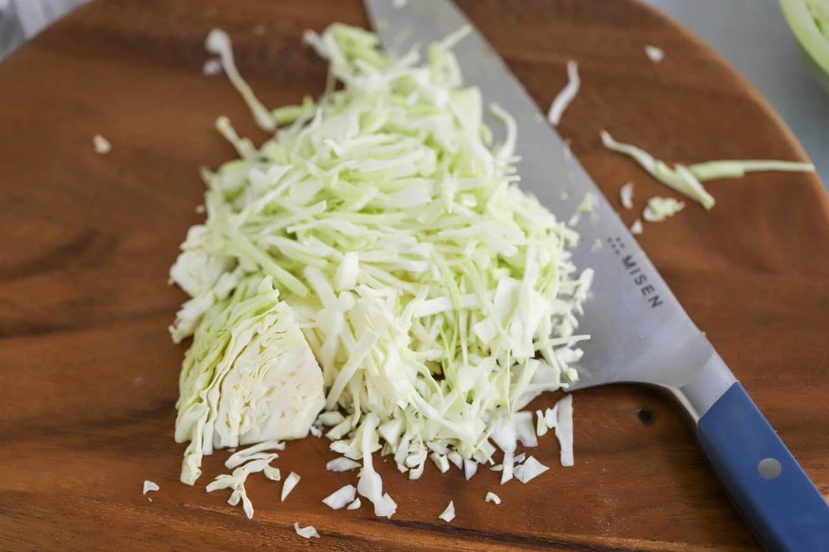 Cabbage sliced by hand with chopping knife.