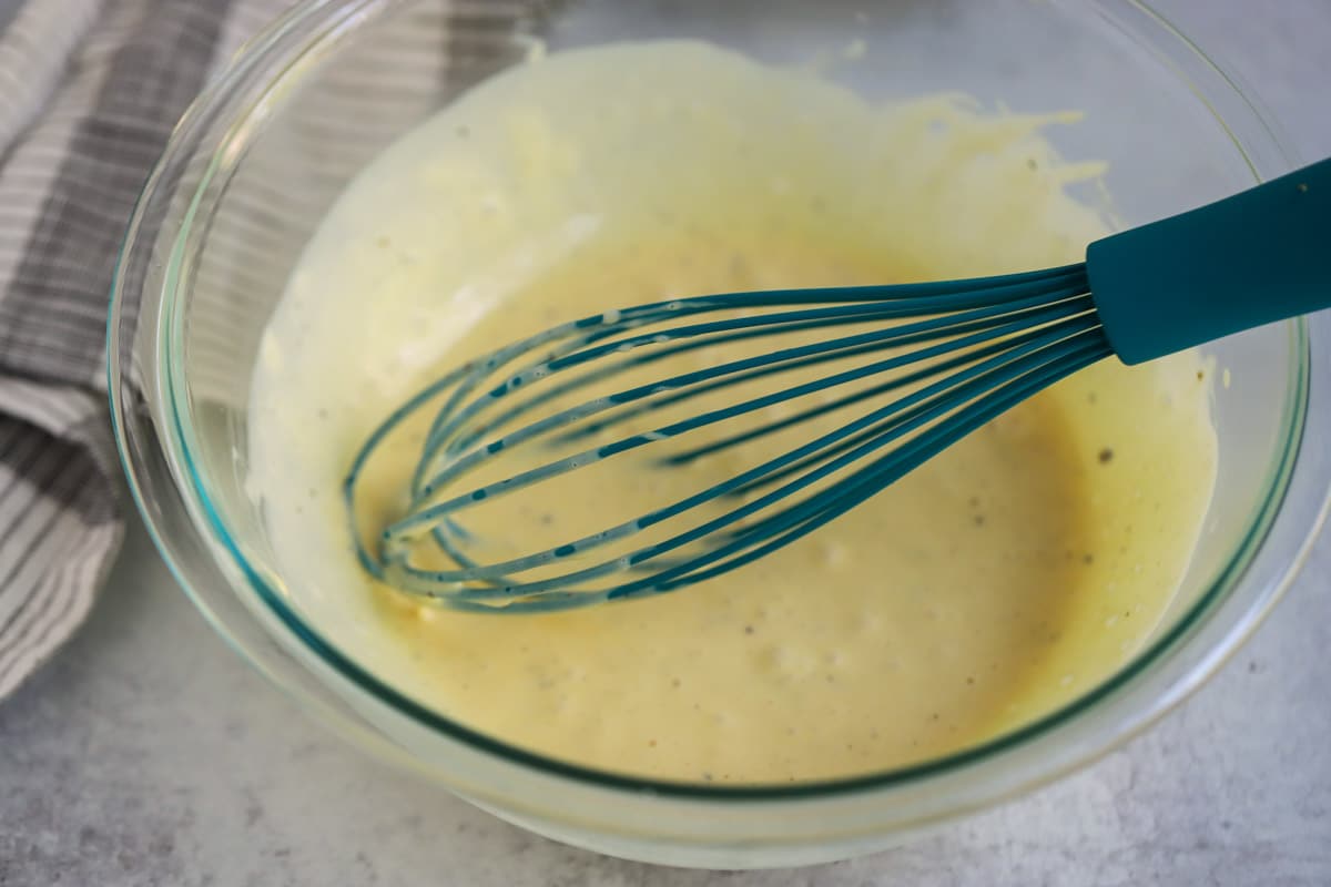 Bowl with whisked coleslaw dressing.