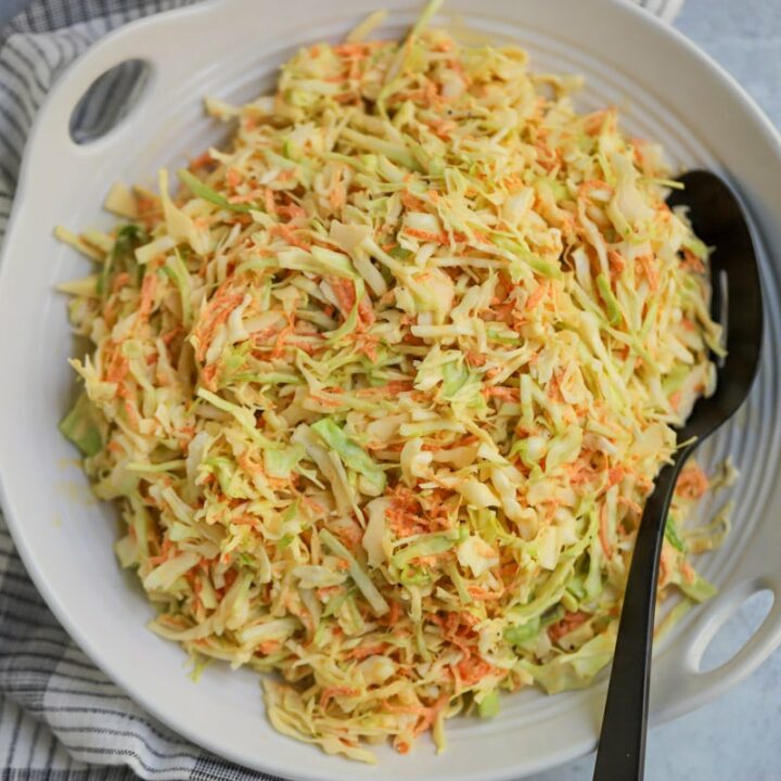 Coleslaw plated in white serving dish.