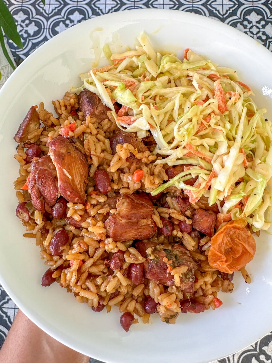 Trinidadian chicken pelau in white plate with homemade coleslaw recipe alicaspepperpot.