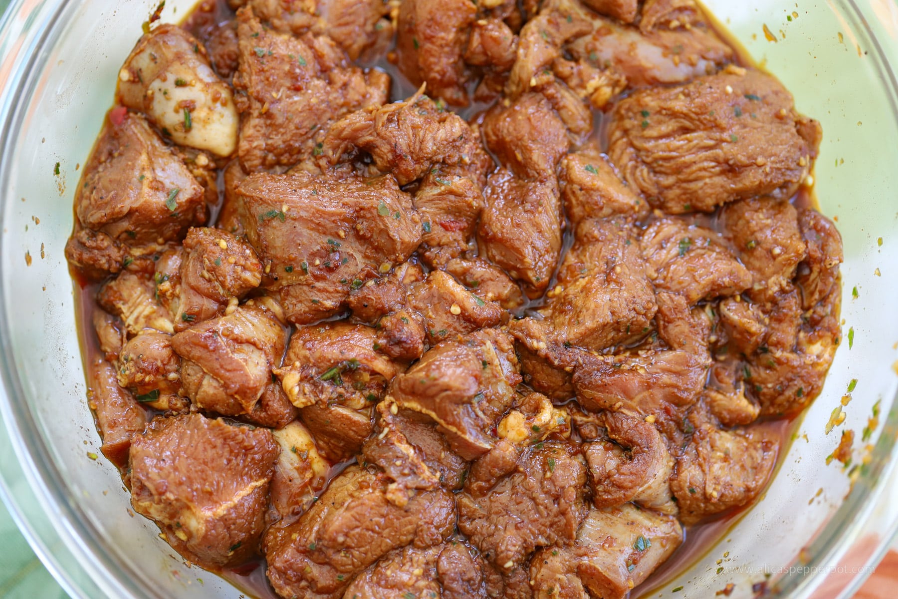 Raw lamb marinating in seasoning for casareep lamb dish.