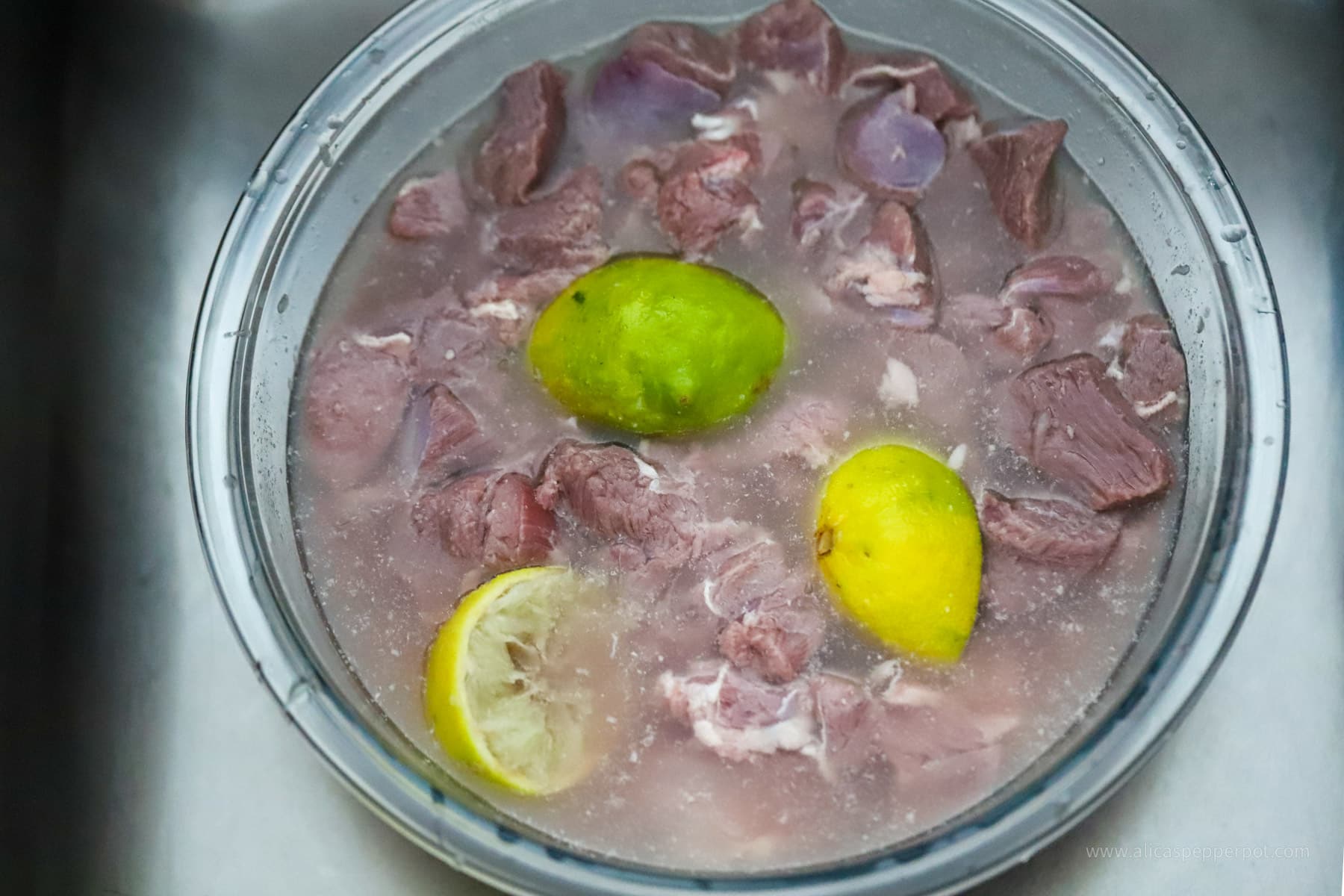 Bowl of lamb meat soaking in lime water.