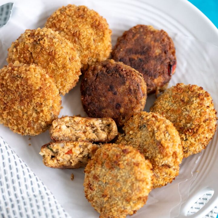 Vertical image of cooked salmon cakes in a white platter.