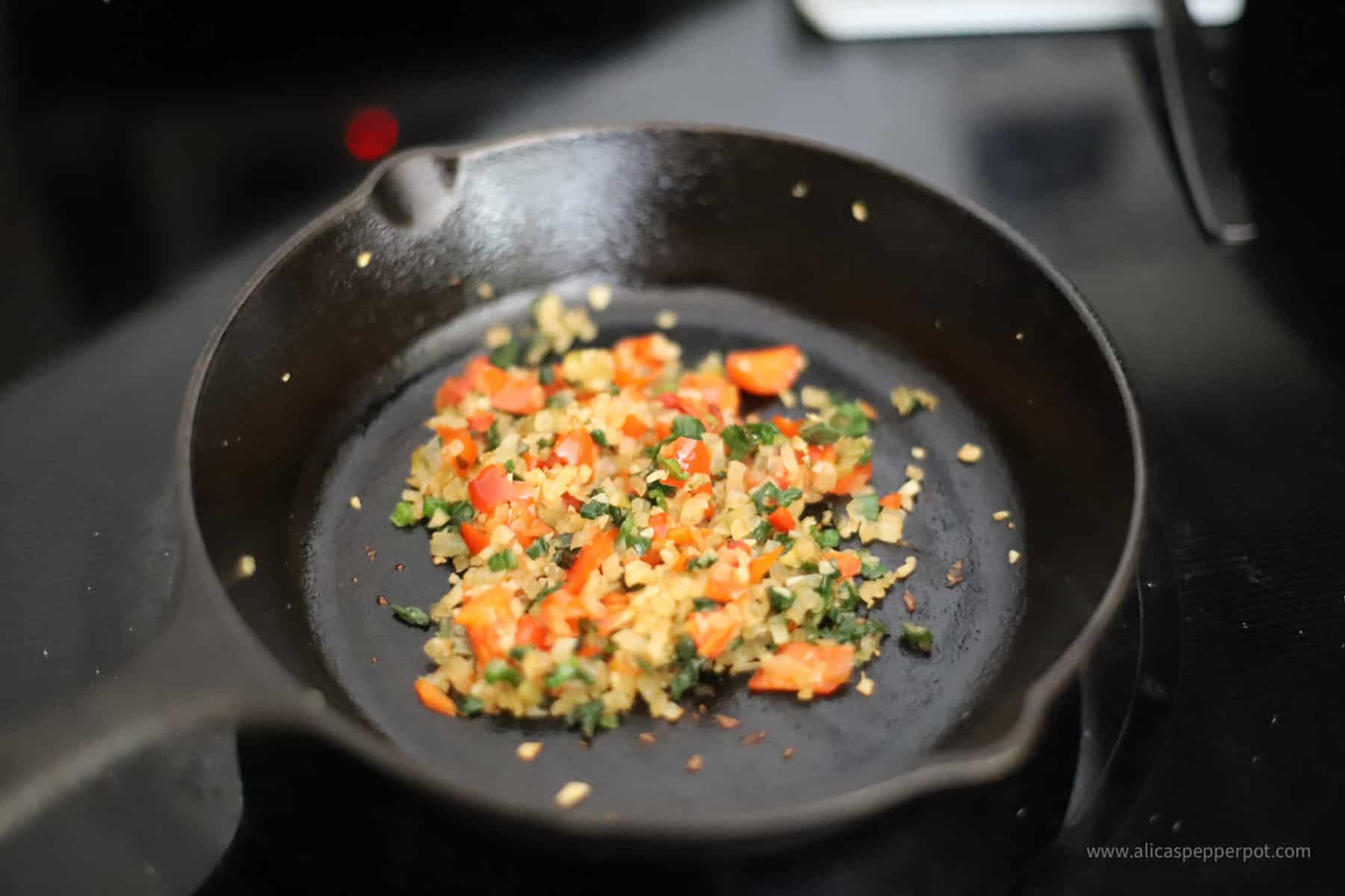 Cooked ingredients in cast iron pan.