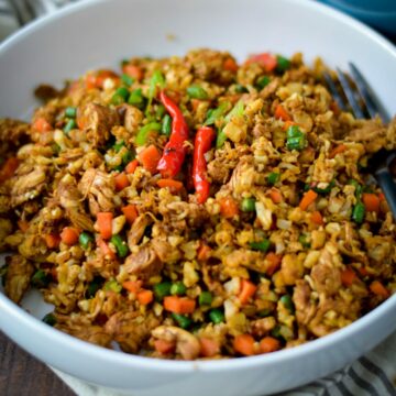 Cauliflower fried rice recipe in a white bowl showing chili peppers